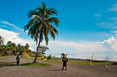 Menschen auf Pfad entlang Strand mit Palme, Kopar, East Sepik Provinz, Papua-Neuguinea, Südpazifik