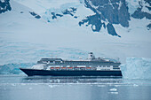 Cruise ship Zaandam (Holland America Line) with ice and mountain backdrop, Neko Harbour, Graham Land, Antarctica