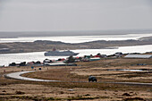 Land Rover on road with expedition cruise ship MS Hanseatic (Hapag-Lloyd Cruises) in harbor, near Stanley, Falkland Islands, British Overseas Territory