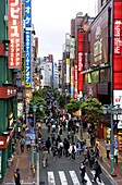 A pedestrian street lined with shops and signboards attracts a crowd in Shinjuku, Tokyo, Japan, Asia