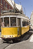A number 28 tram runs along the scenic route popular with tourists in the Alfama district of Lisbon, Portugal, Europe