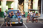 Men relaxing on a 1950s classic American car, Central Havana, Cuba, West Indies, Caribbean, Central America