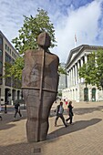 Pedestrians pass the Iron Man sculpture by Antony Gormley 1993 in Victoria Square, Birmingham city centre, West Midlands, England, United Kingdom, Europe