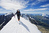 Climber on snow ridge, Aiguille de Bionnassay. on the route to Mont Blanc, French Alps, France, Europe