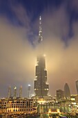 Burj Khalifa illuminates the clouds and surrounding skyline at night, Downtown, Dubai, United Arab Emirates, Middle East