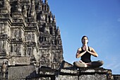 Woman performing yoga, Prambanan complex, UNESCO World Heritage Site, Java, Indonesia, Southeast Asia, Asia