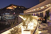 Rooftop terrace bar at the Athens Hilton with Lykavittos Hill illuminated at night, Athens, Greece, Europe