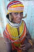 Bonda tribeswoman wearing traditional bead costume with beaded cap, large earrings and metal necklaces at weekly market, Rayagader, Orissa, India, Asia