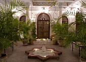 An interior courtyard featuring a marble fountain and palm trees at the Villa des Orangiers in Marrakech, Morocco, North Africa, Africa