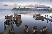 Boats on Derwent Water on a misty autumn morning, Lake District National Park, Keswick, Cumbria, England, United Kingdom, Europe