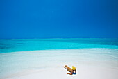 Woman reading a book on the beach, Maldives, Indian Ocean, Asia