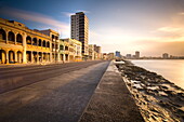 View along The Malecon at dusk showing mix of old and new buildings, Havana, Cuba, West Indies, Central America