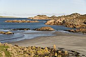 Sand beach between outcrops of pink Ross of Mull granite, Fionnphort, Ross of Mull, western Mull, Inner Hebrides, Scotland, United Kingdom, Europe