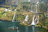 Tourist boats beneath Detian Falls, China and Vietnam transnational waterfall, Guangxi Province, China, Asia