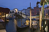 Gondolas moored on the Grand Canal at Riva del Vin, with Rialto bridge behind, Venice, UNESCO World Heritage Site, Veneto, Italy, Europe