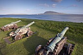 Skansin fort, old fort guarding Torshavn and its harbour, with old brass cannons, Second World War British marine guns and lighthouse, Nolsoy in the distance, Torshavn, Streymoy, Faroe Islands (Faroes), Denmark, Europe