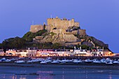 Mount Orgueil Castle, illuminated at dusk, overlooking Grouville Bay in Gorey, Jersey, Channel Islands, United Kingdom, Europe