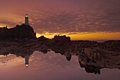 Dramatic sunset and low tide, Corbiere lighthouse, St. Ouens, Jersey, Channel Islands, United Kingdom, Europe