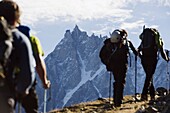 Hikers on Mont Blanc against mountain backdrop of Aiguille du Midi, Chamonix, French Alps, France, Europe