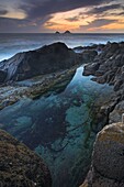 Rockpool at sunset looking towards The Brisons, Porth Nanven, Cornwall, England, United Kingdom, Europe