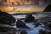 Waves crash against the rocks at sunset at Porth Nanven, Cornwall, England, United Kingdom, Europe