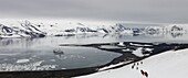 Tourists hiking down the mountainside towards Whalers Bay, Deception Island, South Shetland Islands, Antarctic Peninsula, Antarctica, Polar Regions