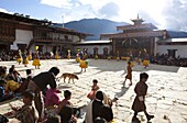 Masked dance in the main courtyard of the Gangte Goemba while local people and tourists watch during the Gangtey Tsechu, Gangte, Phobjikha Valley, Bhutan, Asia