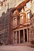 Tourist looking up at the facade of the Treasury (Al Khazneh) carved into the red rock at Petra, UNESCO World Heritage Site, Jordan, Middle East