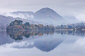 Mist hangs over the lake and island at Grasmere with Helm Crag beyond, Lake District, Cumbria, England, United Kingdom, Europe