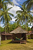 Tourist relaxing in a hammock on a bamboo beach hut on the Thai island of Koh Lanta, South Thailand, Southeast Asia, Asia