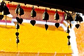 Close up of prayer bells, silhouetted against the colourful roof at Wat Doi Suthep, Chiang Mai, Thailand, Southeast Asia, Asia