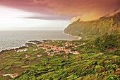sunset and dramatic clouds over Faja Grande with terraces fields, white houses and steep coast, Island of Monchique in the sea, westermost point of Europe, view from the old whale outlook, Island of Flores, Azores, Portugal, Europe, Atlantic Ocean