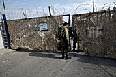 Soldat öffnet ein Tor für einen anderen Soldaten, Militärgelände, Grenze von Israel zu Libanon, Israel