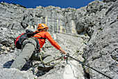 Woman ascending fixed rope route, Hochthronklettersteig, fixed rope route Hochthron, Untersberg, Berchtesgadener Hochthron, Berchtesgaden Alps, Upper Bavaria, Bavaria, Germany