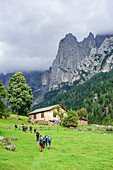 Several persons hiking towards alpine hut, valley Val Canali, Pala range, Dolomites, UNESCO World Heritage Dolomites, Trentino, Italy