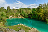 Young woman standing at the shore of turquoise lake Blauer See near Rübeland, Harz Foreland, Harz Mountains, Saxony-Anhalt, Germany