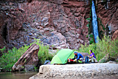 Hikers setup camp on a beach along the Colorado River near the plumeting 180-foot Deer Creek Falls in the Grand Canyon outside of Fredonia, Arizona November 2011.  The 21.4-mile loop starts at the Bill Hall trailhead on the North Rim and descends 2000-fee