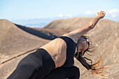 Girl doing yoga on the top of a volcano in Fuerteventura, Canary Islands