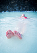 A young girl enjoys the Blue Lagoon, a geothermal spa in Southwest Iceland.