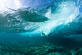 Surfers wiping out on the shallow reef in maldives