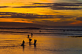 Surfers at sunrise.