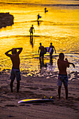 Surfers at sunrise.