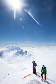 Climbers and rangers Dave Weber and Tom Ditolla are on a snow ridge of the West Rib high on Mount McKinley. Dave is pointing to the summit of McKinley, Mount Hunter is seen in the background.     Mount McKinley or Denali is the highest mountain peak in No