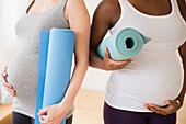 Pregnant women carrying yoga mats