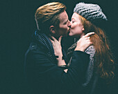 Couple wearing warm clothing kissing