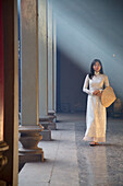 Woman wearing ao dai dress at Thien Hau Pagoda, Cholon, Ho Chi Minh City, Vietnam, Indochina, Southeast Asia, Asia