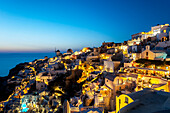 'Buildings on a hillside illuminated at dusk; Oia, Santorini, Greece'