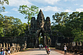 'South gate of Angkor, connecting Bayon Wat and Angkor Wat, in the laterals many buddhas are holding a big snake, the gate is made by a tower with four buddha faces; Siem Reap, Cambodia'