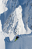'High angle view of snowboarder walking along snowy ridge; Methven, New Zealand'