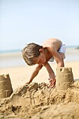 Little boy making a sand castle on the beach